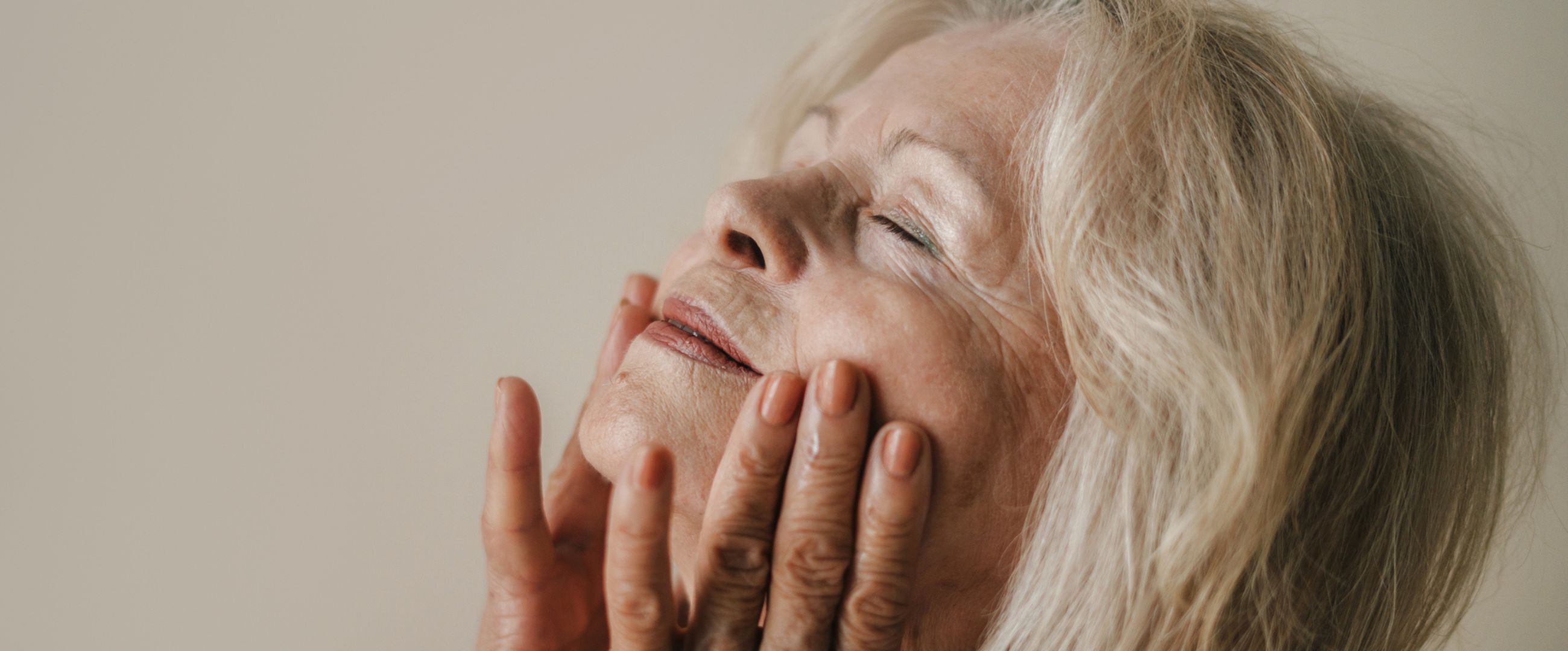 Older woman touching her face